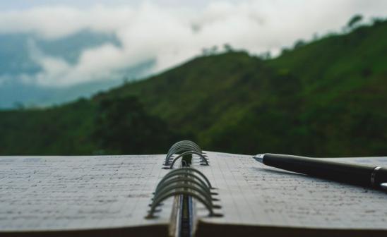 opened notebook with a pen sitting on top