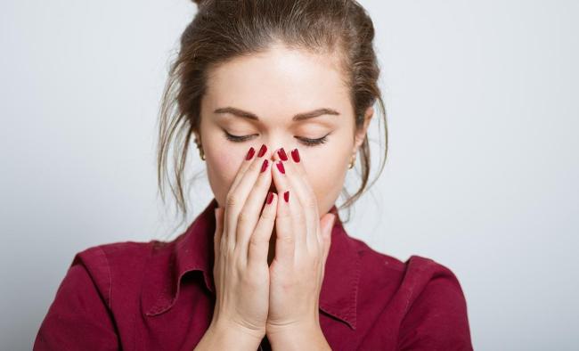 woman with hands over her nose and mouth