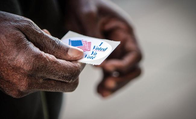 hand holding a voting sticker