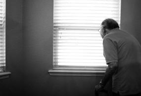 an elderly man looking out of a window