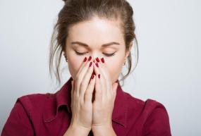 woman with hands over her nose and mouth