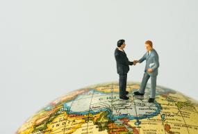 Two miniature figures shaking hands over China