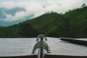 opened notebook with a pen sitting on top
